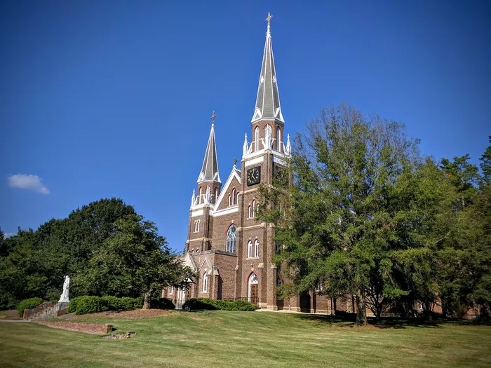 Belmont Abbey's twin spires against a blue sky